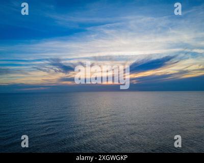 Beau coucher de soleil et paysage nuageux coloré sur une mer Baltique légèrement vallonnée, Lituanie. Photo drone aérien Banque D'Images