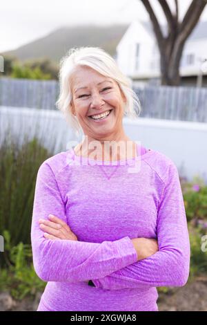 Portrait vertical de femme caucasienne senior heureuse avec les cheveux blancs souriant à l'extérieur. Bien-être, santé et mode de vie actif des aînés, inaltérés. Banque D'Images