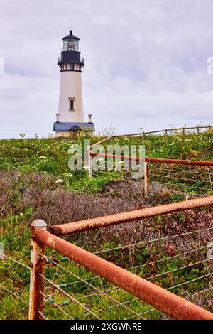 Phare de Yaquina Head avec porte rouillée et verdure perspective basse Banque D'Images