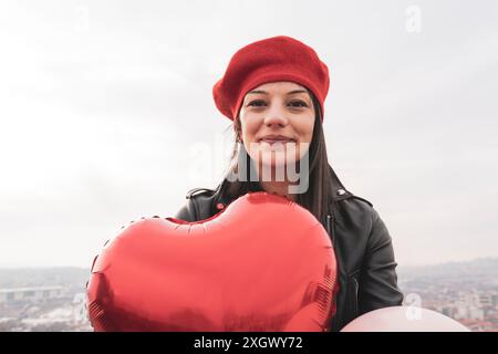 femme tenant des ballons colorés contre le ciel Banque D'Images