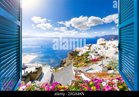 Vue depuis une fenêtre ouverte avec des volets bleus et des fleurs, de la mer Égée, de la caldeira et de la ville blanchie à la chaux d'Oia, Santorin, Grèce. Banque D'Images