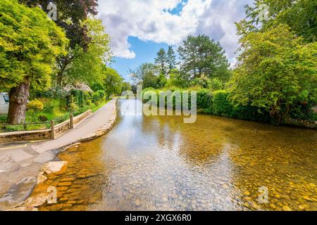 Vue sur la rivière Windrush qui traverse le village pittoresque de Bourton-on-the-Water, en Angleterre, dans le district rural de Cotswold. Banque D'Images