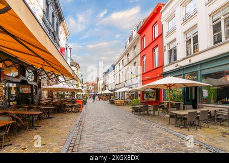 Vue sur les rangées colorées de cafés sur le trottoir de la rue Oudburg, la principale rue piétonne de magasins et de restaurants dans la ville médiévale de Gand, la vieille ville de Belgique. Banque D'Images