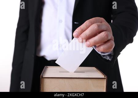 Homme mettant son vote dans l'urne sur fond blanc, gros plan Banque D'Images