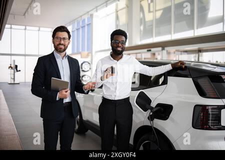 Concessionnaire vend SUV électrique à l'homme d'affaires dans la concession automobile Banque D'Images