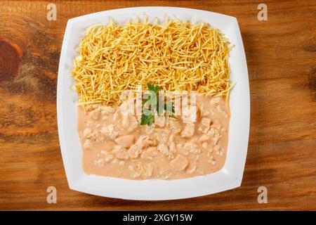 poulet stroganoff maison dans un plat en céramique isolé sur une table en bois. Vue de dessus Banque D'Images