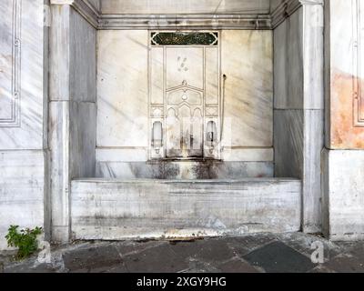 Istanbul, Turquie - 8 mai 2024 : fontaine ornée vieillie reflète le bilan du temps. Banque D'Images