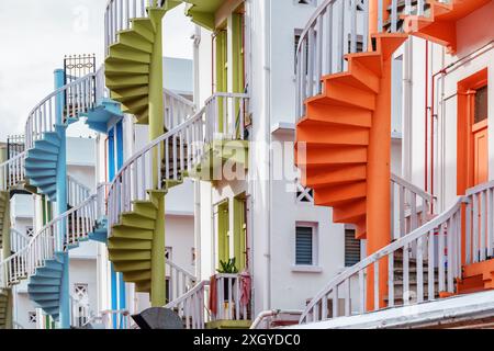 Escaliers en colimaçon extérieurs colorés pittoresques devant un bâtiment blanchi à la chaux à Singapour. Singapour est une destination touristique populaire de l'Asie. Banque D'Images
