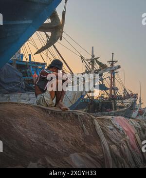 Jakarta, Indonésie - 9 mai 2024. Il est assis près de la goélette Phinisi à Sunda Kelapa. Harbor. Banque D'Images