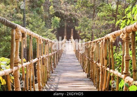 Incroyable pont suspendu simple au-dessus de la gorge. Belle passerelle faite de corde et de bambou. Pont suspendu pittoresque parmi les bois verts. Banque D'Images