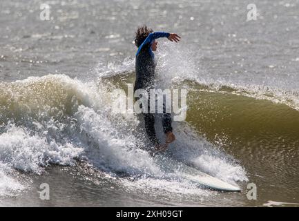 Gilgo Beach, New York, États-Unis - 31 août 2023 : adolescent tombant et se tordant de sa planche de surf en surfant dans l'océan au large de la côte de long Is Banque D'Images