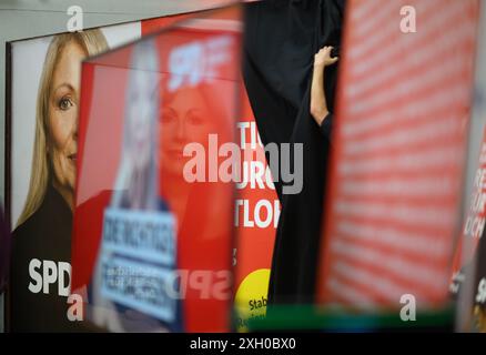 Dresde, Allemagne. 11 juillet 2024. Un employé du SPD dévoile une affiche mettant en vedette Petra Köpping (SPD), ministre des Affaires sociales de Saxe et premier candidat pour les élections d'État, lors de la présentation de la campagne pour les élections d'État en Saxe à la Maison Herbert Wehner. Crédit : Robert Michael/dpa/Alamy Live News Banque D'Images