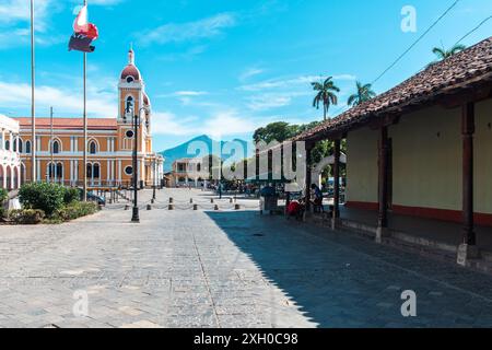 Grenade, Nicaragua - 24 mars 2019 : Cathédrale et plaza animées par la vie sur fond de montagne. Banque D'Images