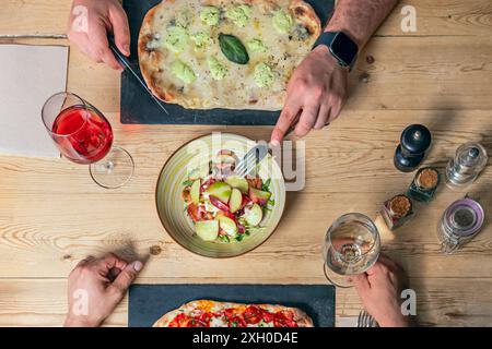 Autour de la table, plusieurs personnes sont confortablement assises sur des chaises en bois Banque D'Images