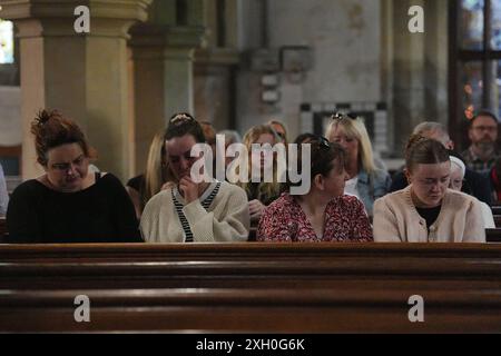 Les membres de la congrégation qui assistaient à un service matinal et à une veillée à l'église St James de Bushey, après la mort de Carol Hunt, 61 ans, l'épouse du commentateur John Hunt de BBC Five Live Racing, et deux de leurs filles, Hannah, 28 ans, et Louise, 25 ans, qui ont été tués dans une attaque d'arbalète à leur domicile, mardi à Bushey, Hertfordshire. Date de la photo : jeudi 11 juillet 2024. Banque D'Images