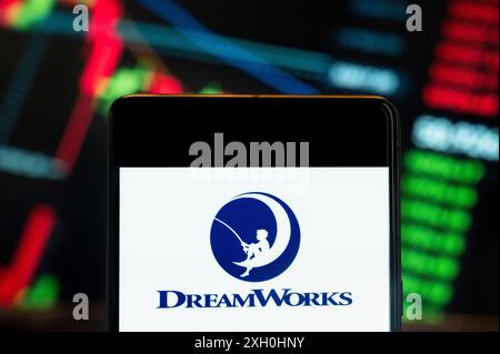 Dans cette illustration photo, le logo du label de production cinématographique américain DreamWorks vu affiché sur un smartphone avec un graphique de l'indice boursier économique en arrière-plan. (Photo de Budrul Chukrut / SOPA images / SIPA USA) *** strictement à des fins éditoriales *** Banque D'Images