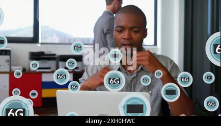 Image de texte 5g et 6g avec des symboles sur l'homme afro-américain réfléchi travaillant sur ordinateur portable. Composite numérique, exposition multiple, entreprise, télétravail Banque D'Images