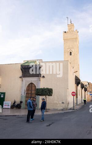 Trois hommes discutent tranquillement dans la rue à côté d'une mosquée dans la ville de Fès au Maroc, Afrique du Nord Banque D'Images