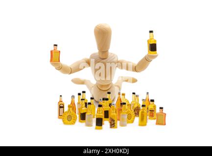 l'homme avec la boisson, un mannequin en bois couché tient des bouteilles de boisson à côté d'une pile de bouteilles de boisson miniatures Banque D'Images