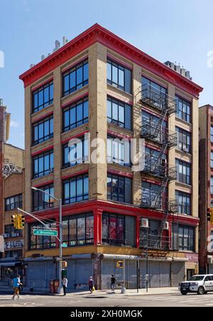 NYC Chinatown : ce loft commercial sur East Broadway semble vacant, ses magasins au niveau de la rue sont tous obturés par des portes de sécurité en acier enroulables. Banque D'Images