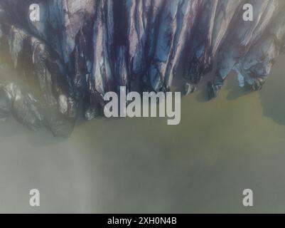 Vue aérienne des formations glaciaires spectaculaires du glacier Sólheimajokull en Islande, mettant en valeur les motifs et textures saisissants de la glace glaciaire. Banque D'Images