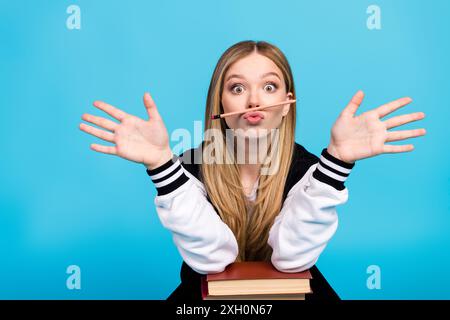 Photo de mignon drôle jolie fille porter des vêtements à la mode ont des mains amusantes paumes isolées sur fond de couleur bleue Banque D'Images