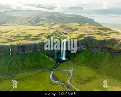 Vue aérienne de la cascade Seljalandsfoss en Islande, entourée de paysages verdoyants Banque D'Images