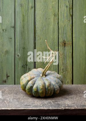 Courge d'hiver Butternut chinoise sur une vieille table en bois avec fond vert Banque D'Images