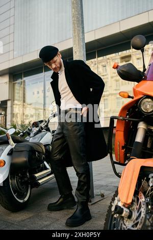 Jeune homme aux cheveux roux en tenue debonair debout à côté d'une moto garée dans la ville. Banque D'Images