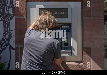 Homme retirant de l'argent d'un distributeur automatique de billets, Nuremberg, moyenne Franconie, Nuremberg, Allemagne Banque D'Images