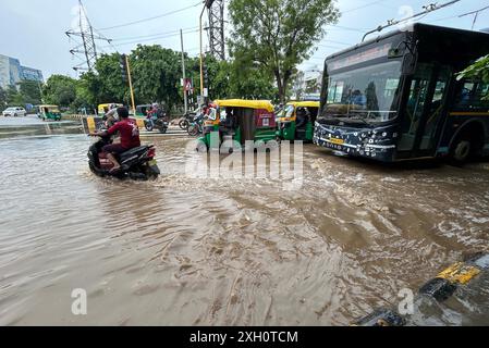 GURUGRAM, INDE - 9 JUILLET : des véhicules pataugeaient dans une étendue d'eau après la pluie sur la route du secteur 47 près de Bakhtawar chowk, le 9 juillet 2024 à Gurugram, en Inde. De fortes pluies ont provoqué un engorgement important dans de nombreuses régions, laissant les résidents et les navetteurs bloqués, et provoquant un blocage considérable de la circulation. L'engorgement dans de nombreuses régions a conduit à détourner les lignes de bus. (Photo de Parveen Kumar/Hindustan Times/Sipa USA ) Banque D'Images