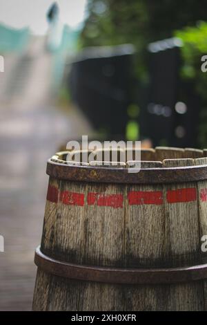 Cette photographie captivante présente une vue rapprochée d'un vieux tonneau en bois avec une patine altérée, mettant en valeur son charme rustique et son attrait vintage. Banque D'Images