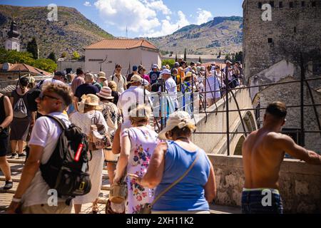 Mostar, Bosnie-Herzégovine. 11 juillet 2024. Les touristes regardent le musulman bosniaque Emel Tiro sauter du vieux pont de Mostar dans le cadre de la commémoration du 29e anniversaire du massacre de Srebrenica à Mostar, Bosnie-Herzégovine, le 11 juillet 2024. Photo : Denis Kapetanovic/PIXSELL crédit : Pixsell/Alamy Live News Banque D'Images
