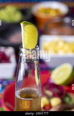 Lime dans une bière avec tortilla mexicaine et salsas Banque D'Images