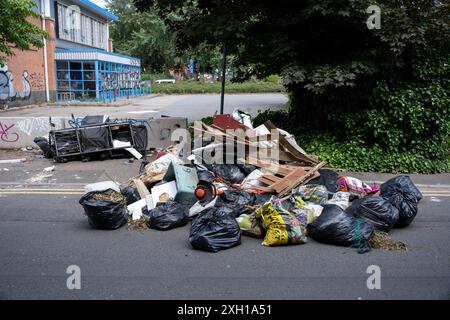 Site de basculement de mouches le 24 juin 2024 à Birmingham, Royaume-Uni. Le déversement illégal, également appelé déversement de mouches ou déversement de mouches, est le déversement illégal de déchets au lieu d'utiliser une méthode autorisée telle que la collecte en bordure de trottoir ou l'utilisation d'une décharge autorisée, et est considéré comme un comportement antisocial et un fléau pour de nombreuses communautés. Il s'agit du dépôt illégal de tout déchet sur terre, y compris les déchets déversés ou déversés sur un site sans autorisation d'accepter des déchets. Banque D'Images