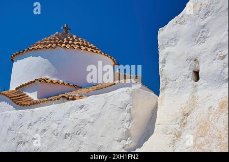 Église blanche avec toit de tuiles rouges et croix sur le dessus, devant un ciel bleu clair, Chora, vieille ville, Patmos, Dodécanèse, îles grecques, Grèce Banque D'Images