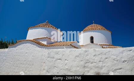 Deux tours d'église peintes en blanc avec des toits ronds en tuiles rouges contre un ciel bleu vif, Chora, vieille ville, Patmos, Dodécanèse, îles grecques, Grèce Banque D'Images