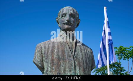 Emmanuel Xanthos, héros populaire, statue en bronze d'un homme avec une barbe à côté d'un drapeau grec contre un ciel bleu clair, Chora, vieille ville, Patmos, Dodécanèse Banque D'Images