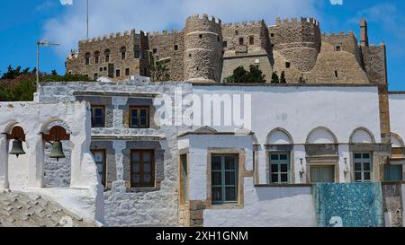 Vieux château au-dessus des maisons blanches traditionnelles avec un ciel bleu sans fin et un soleil éclatant, monastère de Saint Jean, monastère de Saint Jean le théologien Banque D'Images