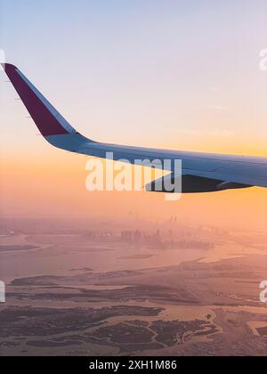 Point de vue des passagers fenêtre panorama de l'horizon d'Abu Dhabi et de la ville avec des rivières et un paysage déserté au coucher du soleil. Volez avec des compagnies aériennes à bas budget holi Banque D'Images