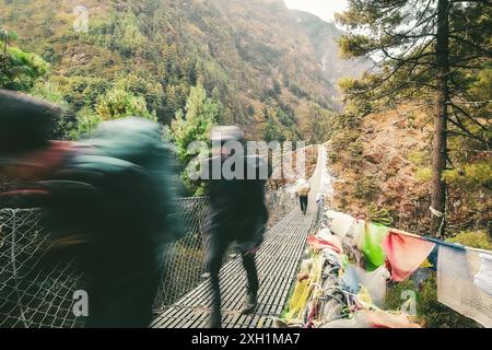 Groupe de trekking caucasien sur le célèbre pont Hilllary au Népal en plein air entouré par la nature d'automne. Matinée fraîche et voyage à l'extérieur à l'automne Banque D'Images