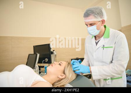 Patiente subissant une exérèse chirurgicale d'un kyste sébacé de la tête Banque D'Images