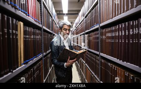 Berlin, Allemagne. 11 juillet 2024. Jonas Fansa, directeur des opérations de la Bibliothèque centrale et d'État de Berlin, vérifie les livres sur les étagères après des dégâts d'eau dans un bâtiment de la Bibliothèque centrale et d'État. Crédit : Britta Pedersen/dpa/Alamy Live News Banque D'Images