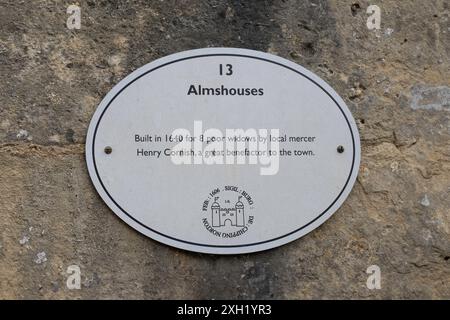 Plaque marquant l'emplacement et l'histoire des almshouses sur un mur à Chipping Norton, Oxfordshire Cotswolds, Angleterre, Royaume-Uni Banque D'Images