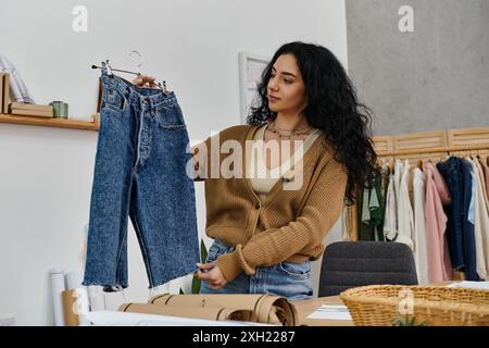 Une jeune femme examine une paire de jeans, explorant des choix de mode durables. Banque D'Images