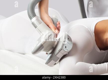 Masseur fait un massage matériel LPG anti-cellulite sur le dos et les mains dans un salon de beauté. Cosmétologie et concept de massage. Banque D'Images