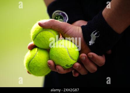 Un gamin de balle tenant des balles de tennis le onzième jour des Championnats de Wimbledon 2024 au All England Lawn Tennis and Croquet Club, Londres. Date de la photo : jeudi 11 juillet 2024. Banque D'Images