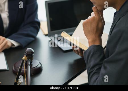 le client rencontre un avocat au sein du bureau du conseiller juridique pour demander des conseils sur la loi et les poursuites qui seront déposées afin d'obtenir un avantage Banque D'Images