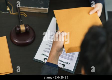 le client rencontre un avocat au sein du bureau du conseiller juridique pour demander des conseils sur la loi et les poursuites qui seront déposées afin d'obtenir un avantage Banque D'Images