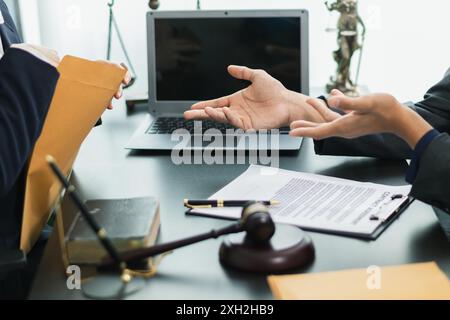 le client rencontre un avocat au sein du bureau du conseiller juridique pour demander des conseils sur la loi et les poursuites qui seront déposées afin d'obtenir un avantage Banque D'Images